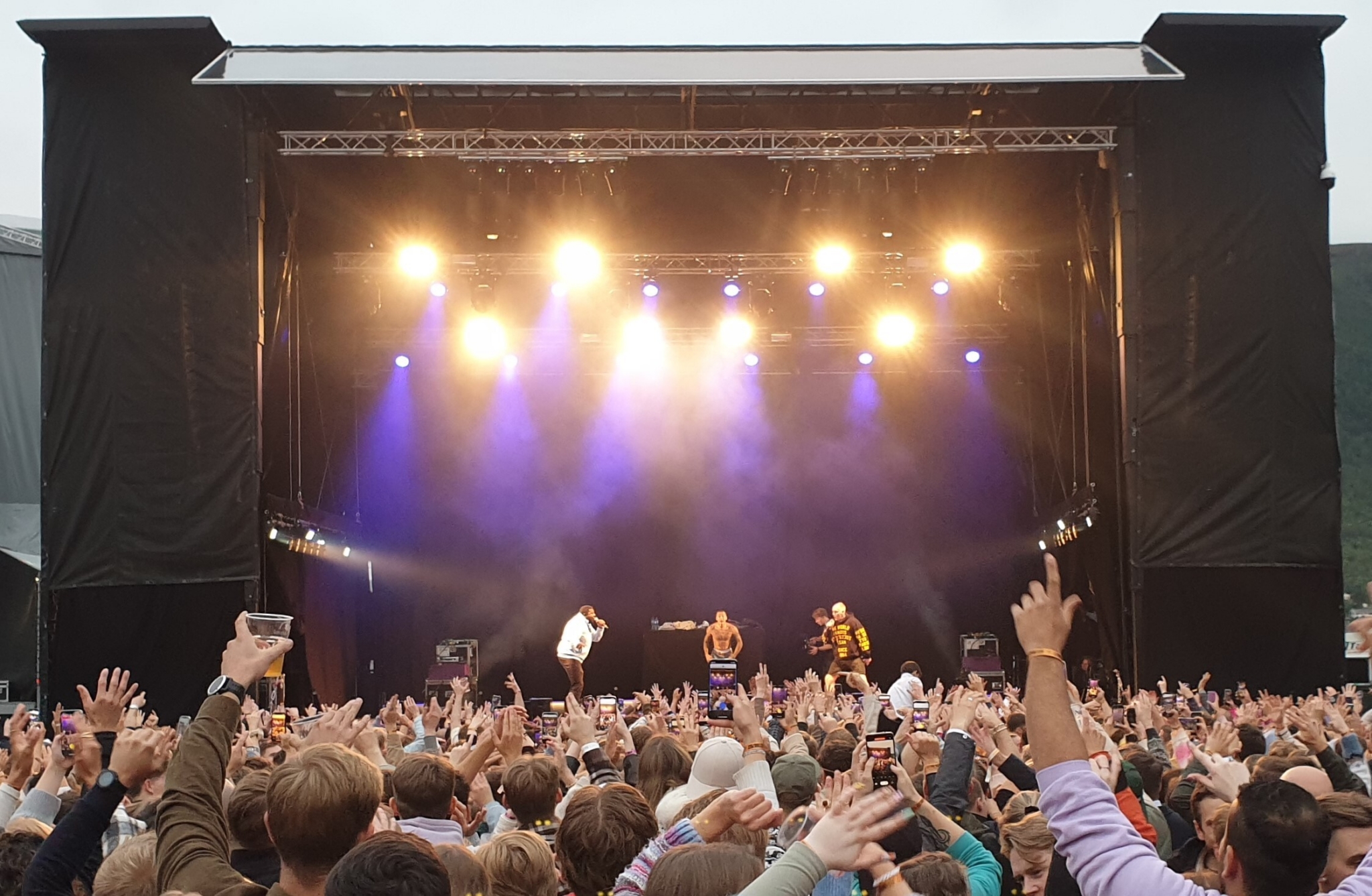 Bilde mot en festivalscene. Publikum har hendene i været, og artisten Kamelen gjør seg klar til å stagedive.